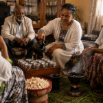 Ethiopian family sharing a traditional coffee ceremony as a woman pours coffee from a jebena.